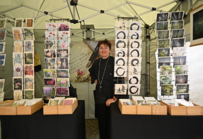Angela Hammer an ihrem Stand mit vielen Postkarten