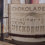 ein gefaltetes Buch mit eingraviertem Text: „Schokolade erweitert dein Speckdrum“