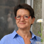 Anne Saile neben Vasenblumen