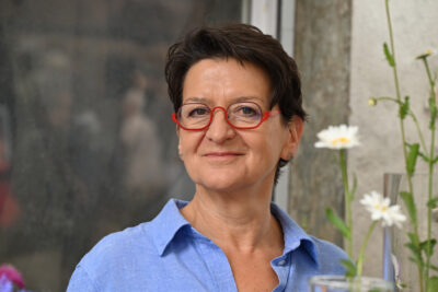 Anne Saile neben Vasenblumen