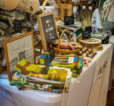 ein Stand mit Stofftaschen, Haargummis und Decken
