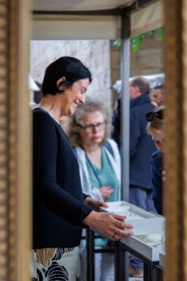 Alexandra Thorn zeigt einer Marktbesucherin einen Kasten mit Schmuck